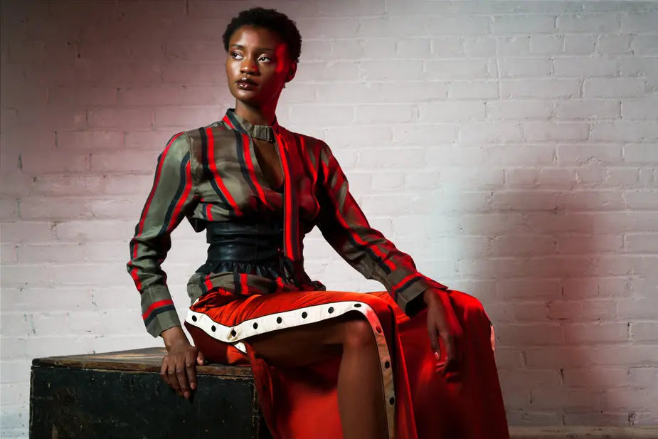 Women's long-sleeve silk blouse with red, black, and white vertical stripes and button details.